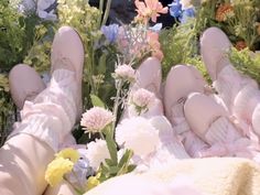 a person's feet in the grass with flowers