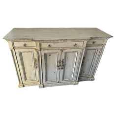 an old white cabinet with two doors and drawers on the front, against a white background