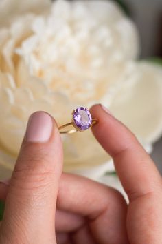 How can something so simple as an oval Amethyst solitaire ring, be so beautiful, you ask? The answer is in the gemstone itself. With a gorgeous vivid purple color, this ring just pops out on your finger and dazzles everyone. To turn it up a notch, add complimentary stacking rings, to create a one-of-a-kind ring set - something extra special for yourself or your loved one. Details: Center gemstone: Amethyst Stone Shape: Oval Measurements: approx. 9x7 mm Weight: approx 1.75 ct Band measurements: a Elegant Purple Oval Birthstone Ring, Purple Oval Birthstone Ring, Oval Solitaire Amethyst Ring For Anniversary, Oval Solitaire Amethyst Promise Ring, Oval Amethyst Birthstone Ring Fine Jewelry, Oval Purple Solitaire Birthstone Ring, Oval Lavender Rings For Promise, Oval Lavender Amethyst Ring For Gift, Oval Lavender Promise Ring