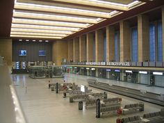 an airport terminal with benches and luggage carts