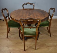 a wooden table with green chairs around it