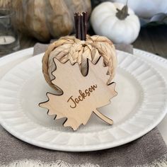 a white plate topped with an apple shaped like a leaf and the word jackson written on it