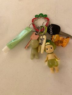 several keychains with various items attached to them on a counter top next to a toothbrush