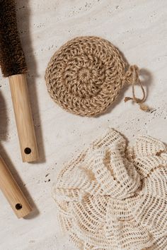 two wooden brushes and a crochet bag on a white surface with some yarn