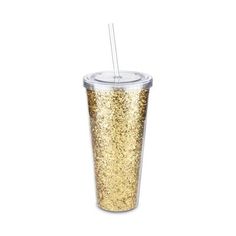 the tumbler cup is filled with gold glitter and has a straw sticking out of it