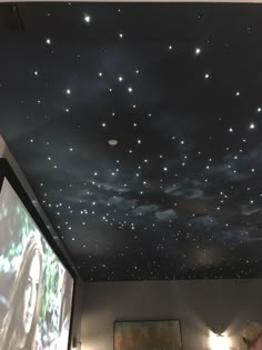 the ceiling is covered with stars and lights in a room that has a projection screen on it