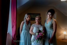 three bridesmaids pose for a photo in their wedding gowns