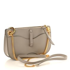 This is an authentic CHLOE Calfskin Tess Mini Crossbody Bag in Motty Grey. This chic crossbody bag is crafted of beige calfskin leather with gold-toned hardware accents, including a prominent gold ring on the front. The bag features a removable gold chainlink crossbody strap with a matching leather shoulder pad and an assortment of pockets. The front flap pocket unsnaps to a beige fabric interior, the top is open to a beige microfiber interior, the top zipper opens to a beige fabric interior, and the back pocket is big enough to hold a cellphone and secure it with a leather strap and snap. Chic Crossbody Bag, Beige Fabric, Mini Crossbody Bag, Mini Crossbody, Crossbody Strap, Flap Pocket, Shoulder Pads, Chain Link, Gold Ring