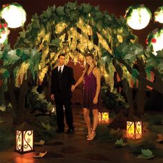 a man and woman standing in front of a archway decorated with lights for their wedding