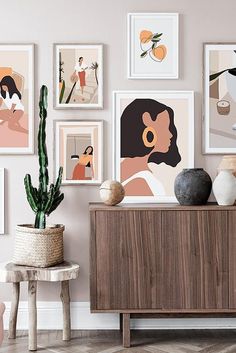 there are many pictures hanging on the wall in this living room with cactus and potted plant