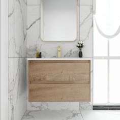 a bathroom vanity with a mirror and vase on the counter next to it in front of a window