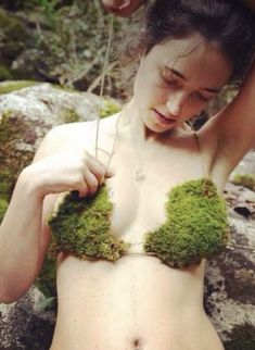 a woman with moss on her chest is posing for the camera