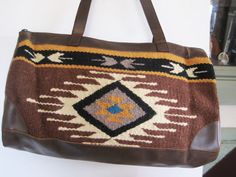 Beautiful Artison Handwoven wool (90% wool, 10% polyester to hold shape) Weekender bag with faux leather straps, bottom and sides  in Southwestern brown and multi-color designs. Note:  this is not real leather but the quality and suppleness is top quality and looks and feels like leather Bag is 18 inches wide, 11 inches high and 5 inches deep.  The handles have a 11 inch drop. There is the same leather on the sides.  Bag is lined in polyester and has one pocket.  Bag has Brown Rectangular Weekender Bag With Leather Trim, Brown Leather Trim Tote Weekender Bag, Bohemian Brown Weekender Bag With Leather Handles, Artisan Brown Bag For Fall, Brown Southwestern Style Shoulder Bag For Everyday Use, Artisan Brown Satchel With Leather Handles, Brown Southwestern Rectangular Shoulder Bag, Southwestern Style Brown Rectangular Shoulder Bag, Southwestern Brown Rectangular Shoulder Bag