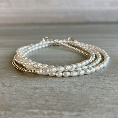 This elegant freshwater pearl bracelet is a modern interpretation of classic pearl jewelry. The tiny round beads frame beautiful rice pearls. At checkout, choose a sterling silver or gold beaded bracelet. To see more pearl jewelry, including a coordinating necklace: www.etsy.com/shop/GemsByKelley/search?search_query=pearl * METAPHYSICAL PROPERTIES OF PEARLS * peace prosperity feminine energy integrity wisdom faith Free gift with every crystal jewelry purchase from Gems by Kelley: a beautiful car Elegant White Wrap Bracelet As Gift, Elegant White Wrap Bracelet For Gift, Elegant White Wrap Bracelet Gift, Everyday White Beaded Wrap Bracelet, Adjustable Single Strand White Bracelet, White Single Strand Bracelet Gift, White Single Strand Bracelet As A Gift, Elegant White Round Bead Friendship Bracelets, White Round Beads Wrap Bracelet For Everyday