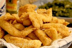 some fried food is sitting on a plate with dipping sauce in the bowl behind it