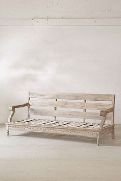 a wooden bench sitting in the middle of a room with white walls and flooring