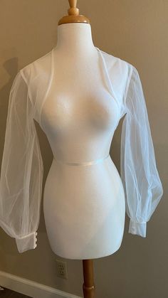 a mannequin is wearing a white top with sheer sleeves on it's shoulders