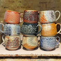 a group of coffee cups sitting on top of a wooden table next to each other