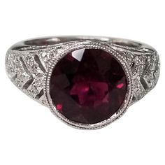 14k white gold garnet and diamond ring, containing 1 round garnet of gem quality weighing 2.98cts. and 38 round full cut diamonds weighing .45pts. This ring is a size 5.5 but we will size to fit for free. Garnet Wedding Rings, Garnet Wedding, Yellow Gold Cocktail Ring, Garnet And Diamond Ring, Ruby Diamond Rings, Platinum Diamond Rings, Vintage Style Rings, Gold Cocktail Ring, Gold And Silver Rings