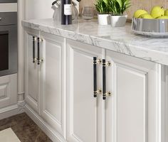 a kitchen with marble counter tops and white cabinets