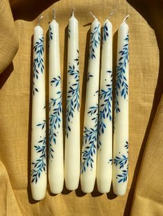 Ivory taper candles are hand painted with a classic blue vine inspired florals. They are on an ochre linen tablecloth. Painted Tapered Candles, Candle Wax Art, Candle Art Painting, Tapper Candles