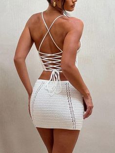 This alluring ensemble features a delicately crafted crochet lace-up top and a matching mini skirt, designed to accentuate your curves and make a bold fashion statement. Perfect for summer parties, beach outings, or a stylish brunch, this set combines comfort and elegance effortlessly. Knit material Sheer crochet construction at front Top Asymmetric hem Plunge neck Deep v neck Halter neck tie Lace up detail at back Backless Sleeveless Mini Skirt Elasticated waistband Low rise Fitted Lace Mini Skirt For Summer, Summer Beach Lace Mini Skirt, Fitted Crochet Top With Hollow Out Details, Fitted Mini Crochet Top For Vacation, Fitted Crochet Lace Top Mini Length, Fitted Crochet Lace Top, Fitted Backless Crochet Top, Fitted Backless Crochet Top For Spring, Fall Sweaters For Women