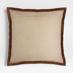 a brown and tan pillow on a white wall with a black border around the edges