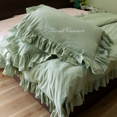 a bed with green ruffled sheets and pillows