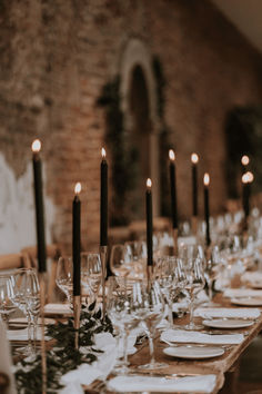 a long table is set with place settings and candles