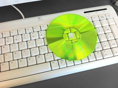 a white keyboard with a green disk on it