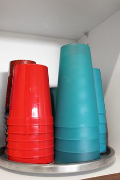 several plastic cups are stacked on top of each other in a storage area with white walls