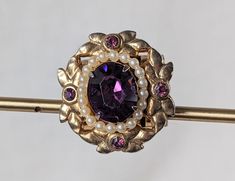 A gorgeous vintage Coro costume slide pendant featuring a glittering purple rhinestone made to look like Amethyst and faux pearls. It is marked "Coro" on the reverse. There are miniscule chips on the corners of the facets of the purple rhinestone. Please look at all the pictures because they are part of the description. Thank you! This pendant measures approximately 7/8" x 7/8". Vintage Purple Brooch For Party, Vintage Purple Brooches For Party, Purple Amethyst Brooch, Vintage Purple Jewelry For Anniversaries, Purple Jeweled Formal Jewelry, Vintage Purple Jewelry For Anniversary, Purple Jeweled Jewelry For Formal Occasions, Purple Vintage Jewelry For Party, Vintage Purple Oval Brooch