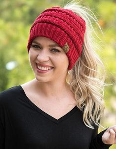 a woman with blonde hair wearing a red knitted hat and black t - shirt