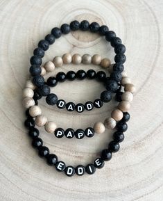 🖤This listing is for one bracelet. Perfect for gifting to the special man, daddy or papa in your life!  🖤Bracelets come in 8mm beads. Choose between three options: black lava beads, wood beads, or shiny black jasper. 🖤Letter beads are round and black with white letters and you can personalize the name you want!  Average men bracelet size:  7.5 Small 8.0 Medium 8.5 Large  9.0 Extra Large  🖤Each bracelet is custom made so all sales are final and no refunds will be issued. Please check all size and personalization ( if needed) prior to ordering.  🖤Tips: Do not get bracelets wet. They may tarnish. Please remove before showering or swimming.  To make it last long, roll the bracelet onto your wrist instead of pulling or stretching it on. Do not leave in direct sun. Store in a safe place whe Adjustable Bracelets For Father's Day Gift, Adjustable Bracelets As Father's Day Gift, Customizable Bracelets For Father's Day, Customizable Adjustable Bracelets For Father's Day, Personalized Black Beaded Bracelets For Father's Day, Custom Name Adjustable Bracelets For Father's Day, Personalized Bracelets For Father's Day, Customizable Black Name Bracelet For Father's Day, Casual Personalized Jewelry For Father's Day