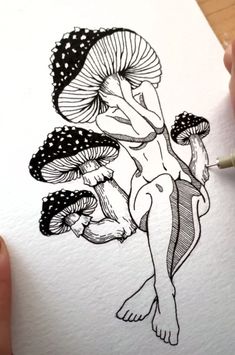 someone is drawing a mushroom on paper