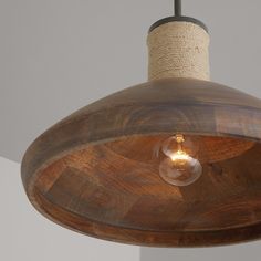 a wooden light fixture with a rope wrapped around it's end and an old fashioned bulb hanging from the ceiling