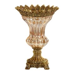 an ornate glass vase with gold trimmings on the bottom and sides, set against a white background