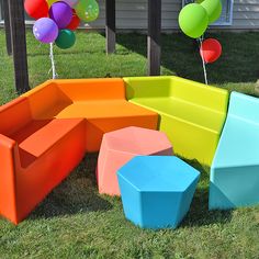 an outdoor play area made out of plastic blocks and balloons in the back yard,