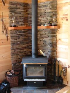 a wood burning stove sitting inside of a living room next to a wall mounted shelf