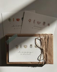 three greeting cards in a box with string tied around them and the words happy birthday written on each card