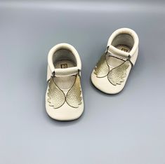 "-Made with 1st grade, 100% genuine calf leather -Handcrafted from start to finish -Angel moccasins are ready to ship for size 12-18 months and will be shipped in 1-2 business days. Made-to-order option is available for other sizes.  -Breathable, soft leather insole -Easy to put on and take off with soft elastic band around ankle -Promotes healthy foot development with four-layered special designed sole; the sole is thick enough for protection while allowing the foot to move naturally.   -Anti-slip sole helps protect your child from slipping -Lightweight, flexible, comfortable, soft and bend easily -Please measure child's foot from heel to big toe before ordering to select the correct size. Add 1/2\" to measurement to get correct sole length. -Leather bow headband sold separately. -If you White Closed Toe Moccasins With Rubber Sole, White Closed Toe Leather Shoes With Leather Sole, White Leather Closed Toe Shoes With Leather Sole, White Leather Shoes With Leather Sole, White Leather Closed Toe Booties, White Soft Sole Booties For First Birthday, Baptism Booties With Soft Sole And Round Toe, White Booties For Baptism, White Closed Toe Booties For Baptism