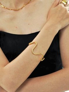 Wavy Open Cuff Bracelet in 18k Gold-Plated, featuring a fluid, organic design, perfect for adding a dynamic and modern touch. Modern Party Cuff Bangle Bracelet, Elegant Irregular Jewelry For Party, Elegant Adjustable Wavy Bracelets, Modern Twist Cuff Bracelet Bangle For Formal Occasions, Modern Twist Bangle Cuff Bracelet For Formal Occasions, Elegant Bangle Bracelets With Unique Design, Elegant Adjustable Wavy Bangle, Elegant Open Cuff Bracelets For Party, Elegant Wavy Oyster Bracelet