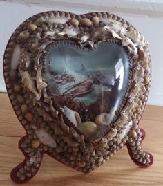 a heart shaped box with seashells in it