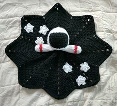 a crocheted black and white hat with a spaceman on it