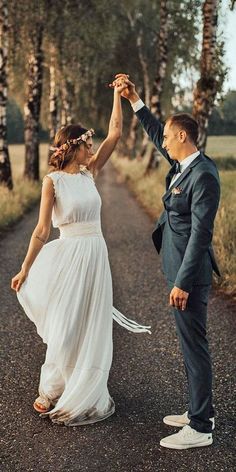 a bride and groom dancing on the road