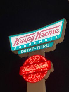 the neon sign for krispy kreme doughnuts is lit up