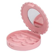 a pink compact mirror sitting on top of a table