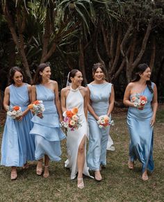 a group of women standing next to each other on top of a grass covered field