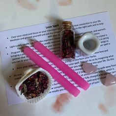 two pink candles sitting on top of a piece of paper