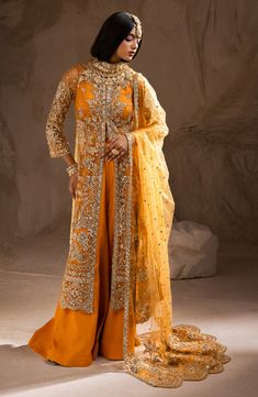 Indian Wedding Dress in Open Jacket and Trouser Style is an embellished attire adorned with hand-crafted embellishments. Premium quality fabric and stylish design of this Indian Dress make it an epitome of beauty and luxury, giving a head-turning look to this attire. Blouse and Jacket: The blouse has an alluring mustard shade and it comes in premium raw silk fabric. The blouse is paired with an embellished Open jacket. The Jacket is fully adorned with embroidery and hand-crafted details of sequi Hand Embellished Organza Gown For Ceremony, Elegant Hand Embellished Dress For Ceremony, Anarkali Hand Embellished Ceremony Dress, Hand Embellished Gown For Ceremony With Traditional Drape, Elegant Embellished Lehenga For Ceremony, Bollywood Style Embellished Gown For Ceremony, Festive Hand Embellished Gown For Ceremony, Anarkali Ceremony Sets Hand Embellished, Elegant Floor-length Sharara For Ceremony